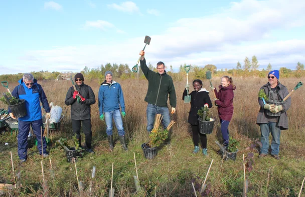Carbon Footprint Ltd team and volunteers with spades and saplings at a UK tree planting day